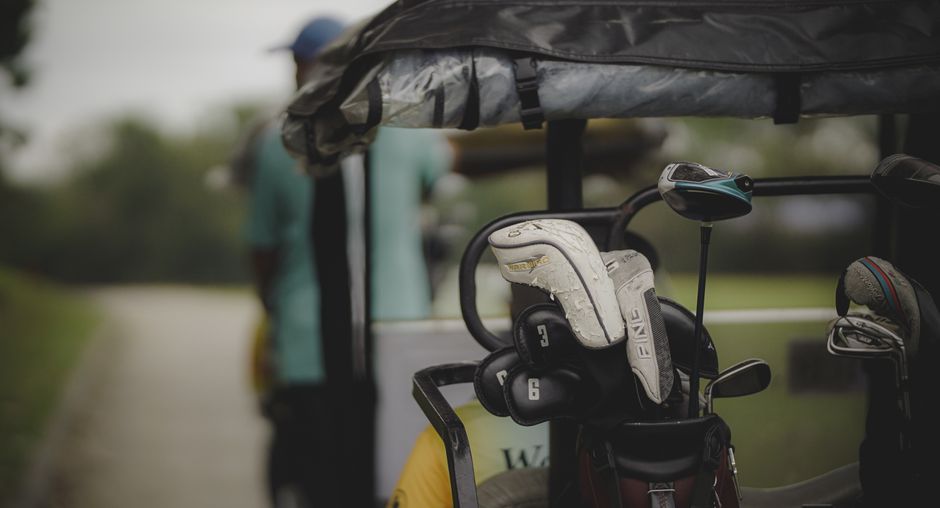 Golf cart bag secured on a riding cart with pockets and a putter well visible